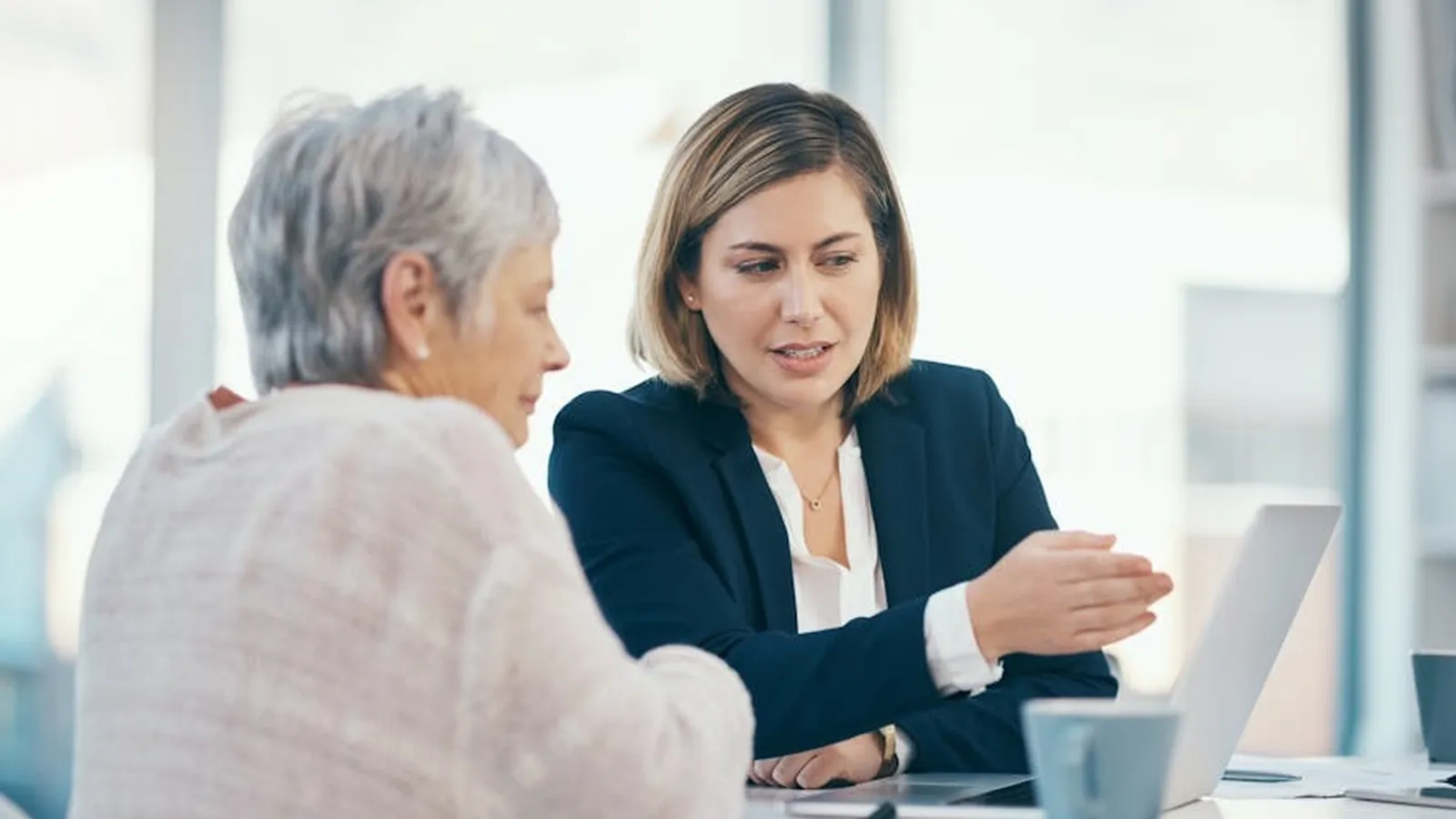Un conseiller en retraite en rendez-vous avec une cliente, dans les bureaux du cabinet